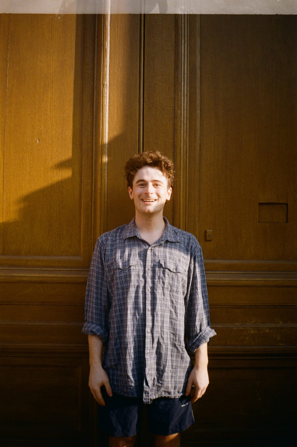 alex smiling in front of wooden doors